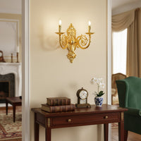 Wall light with polished gold metal frame and ornate detailing styled on a soft wall background for luxurious classic home lighting.