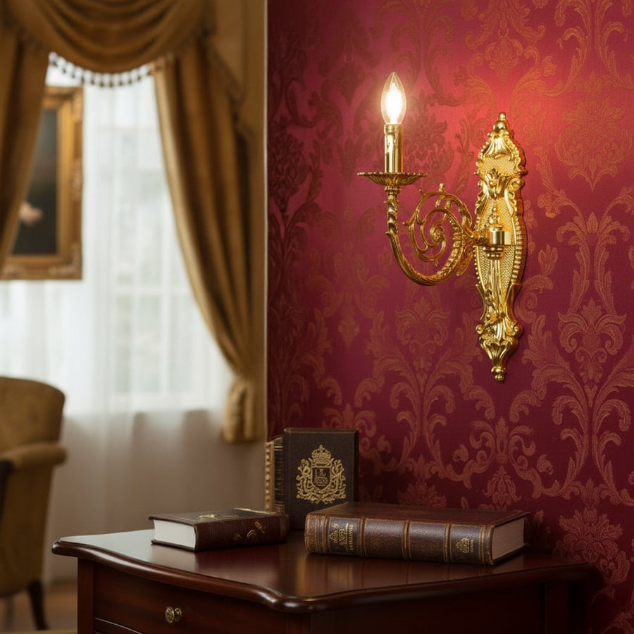 Wall light with gold metal frame and ornate detailing styled on a soft wall background for luxurious classic home lighting.