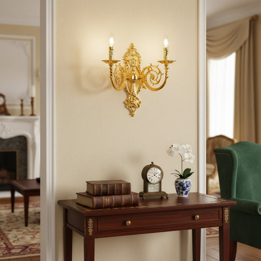 Wall light with polished gold metal frame and ornate detailing styled on a soft wall background for luxurious classic home lighting.
