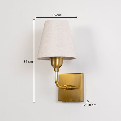 Gold metal wall light with fabric shade measuring 32 cm height 16 cm shade width and 18 cm projection for walls.