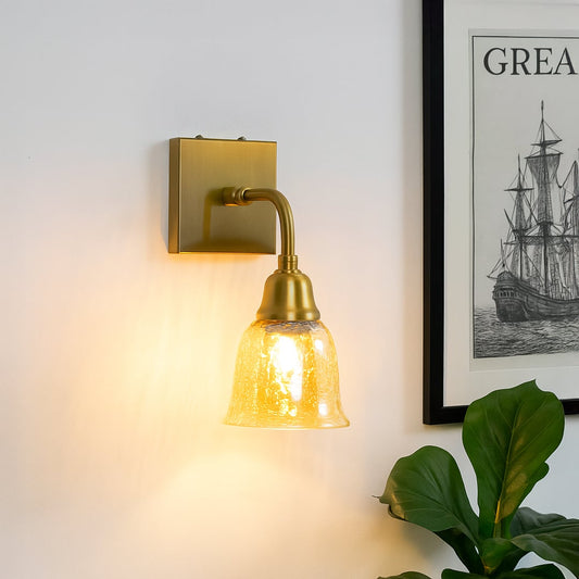 Gold metal wall light with crackle glass shade mounted near bed creating warm ambient lighting for elegant bedroom Decor.