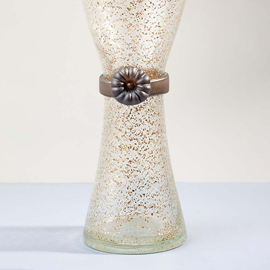 Closeup of tall golden speckled glass vase with metallic floral accent detail showing elegant craftsmanship for decor.
