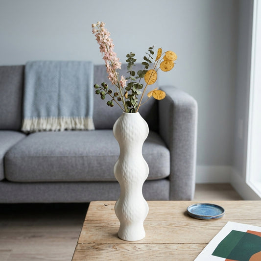 White textured ceramic flower vase with fresh blooms placed on table for elegant modern decor styling.