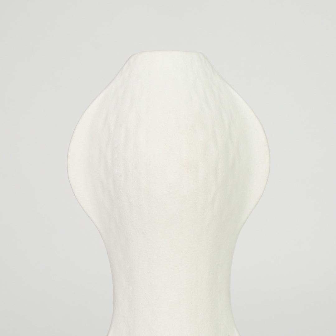 Closeup image of white ceramic abstract vase for modern shelf placement with textured matte artistic finish styling.