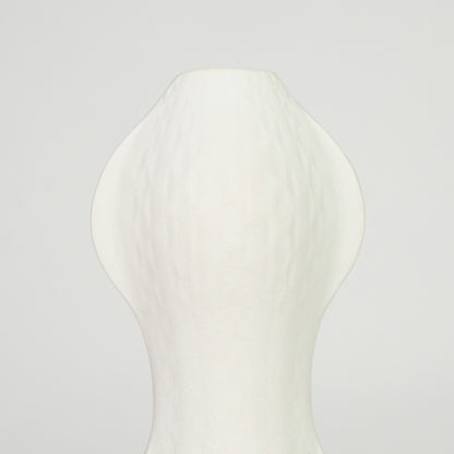 Closeup image of white ceramic abstract vase for modern shelf placement with textured matte artistic finish styling.
