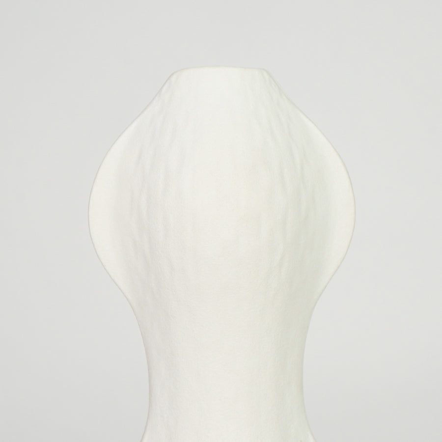 Closeup image of white ceramic abstract vase for modern shelf placement with textured matte artistic finish styling.
