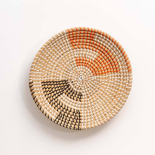 Handwoven seagrass wall basket with orange and black pattern for living room bedroom and entryway decor on white background.