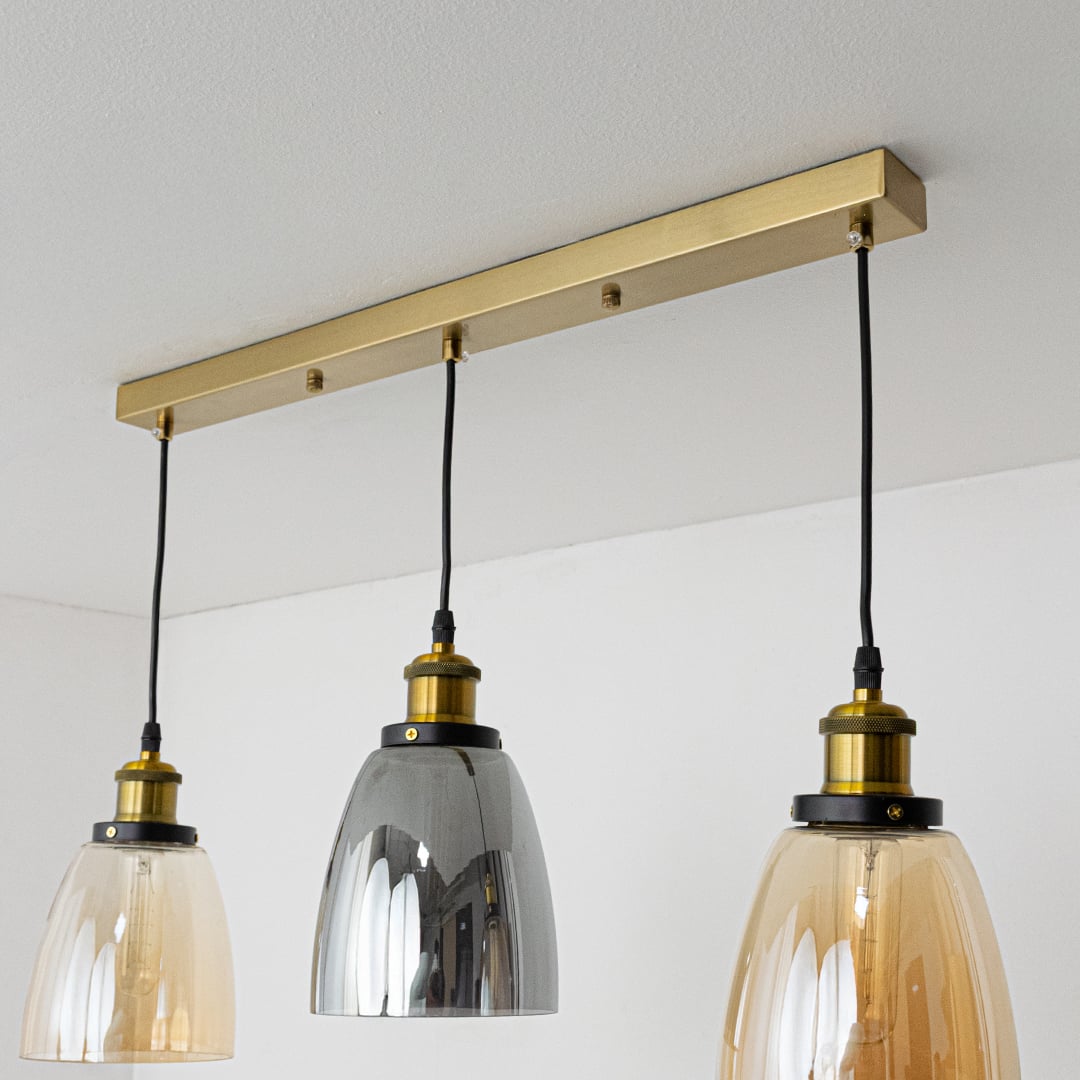 Gold metal linear ceiling canopy with hanging pendants highlighting premium finish and craftsmanship.