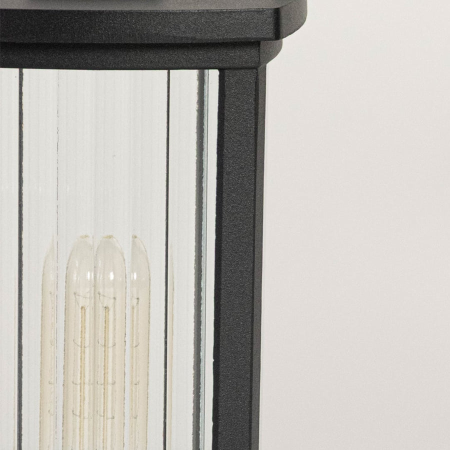 High quality LED bulb closeup inside frosted glass black pillar lamp designed for outdoor balcony and gate decor.