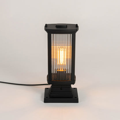 Modern black outdoor gate light with warm glowing bulb for elegant exterior decor styling use.