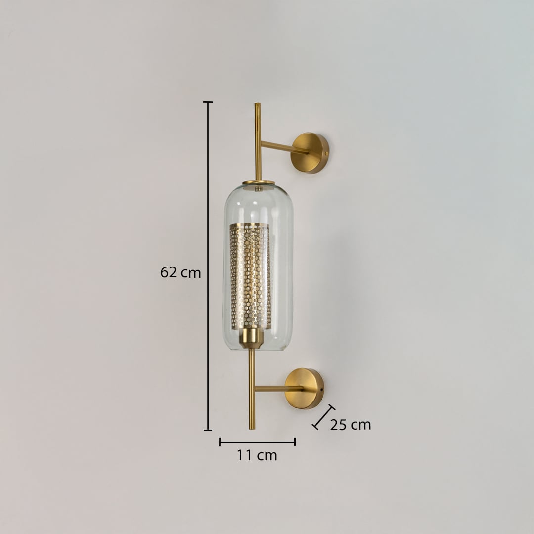 Modern wall light with clear glass cylinder and gold metal body shown with dimensions 62 cm height 11 cm width and 25 cm projection on white wall.