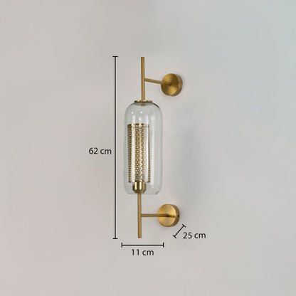 Modern wall light with clear glass cylinder and gold metal body shown with dimensions 62 cm height 11 cm width and 25 cm projection on white wall.