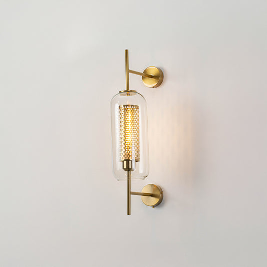 Minimal cylindrical glass wall light with gold metal mount fixed on clean white wall background perfect for elegant modern interior lighting.

