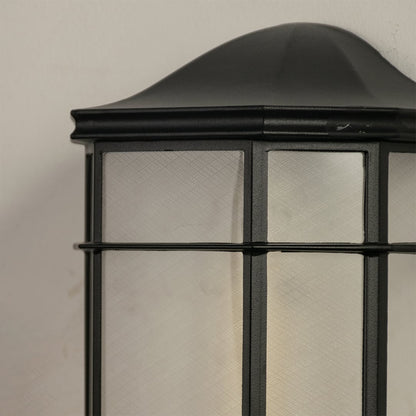 Detailed closeup of black outdoor wall light showcasing frosted glass and sturdy metal frame.