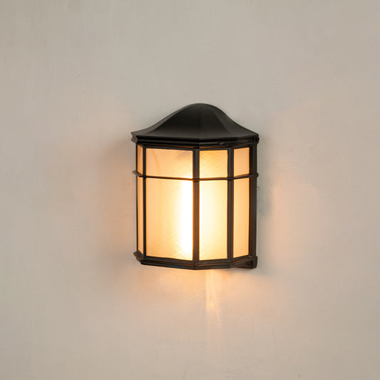 Black aluminum outdoor wall light on white background with a frosted glass panel lattice guard shade for patio decor.