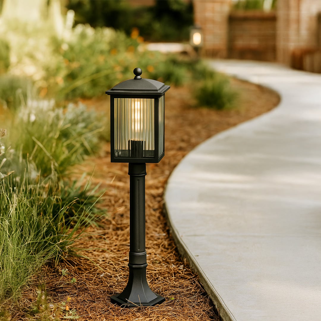 Modern black outdoor post light with ribbed glass body for garden and patio decor shown in a stylish lifestyle setting.