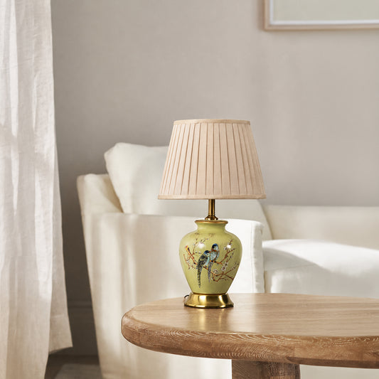 Floral ceramic table lamp with pleated fabric shade and gold accents styled for elegant bedroom and living room decor.