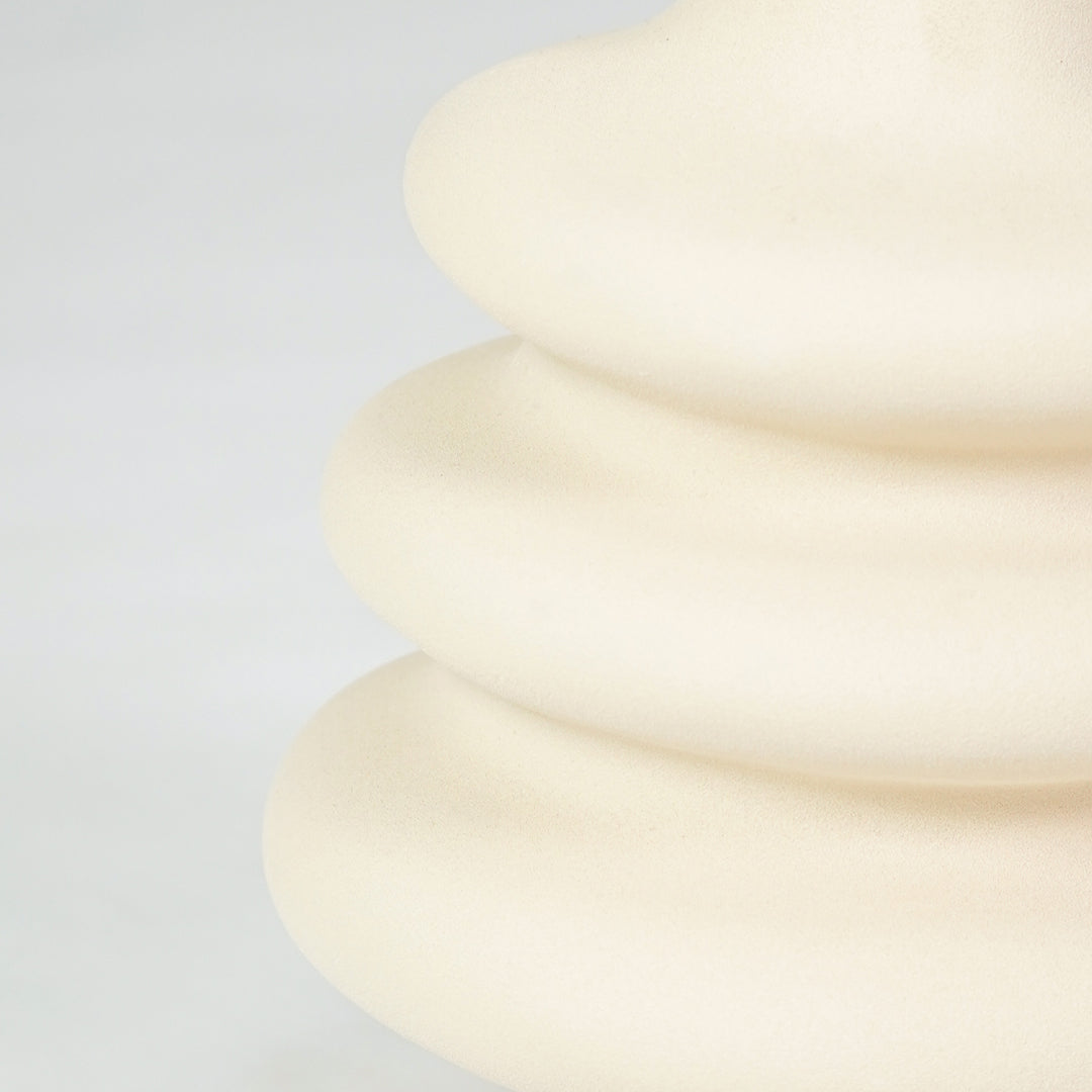 Closeup image of cream ceramic layered vase for modern shelf placement with smooth matte artistic finish styling.