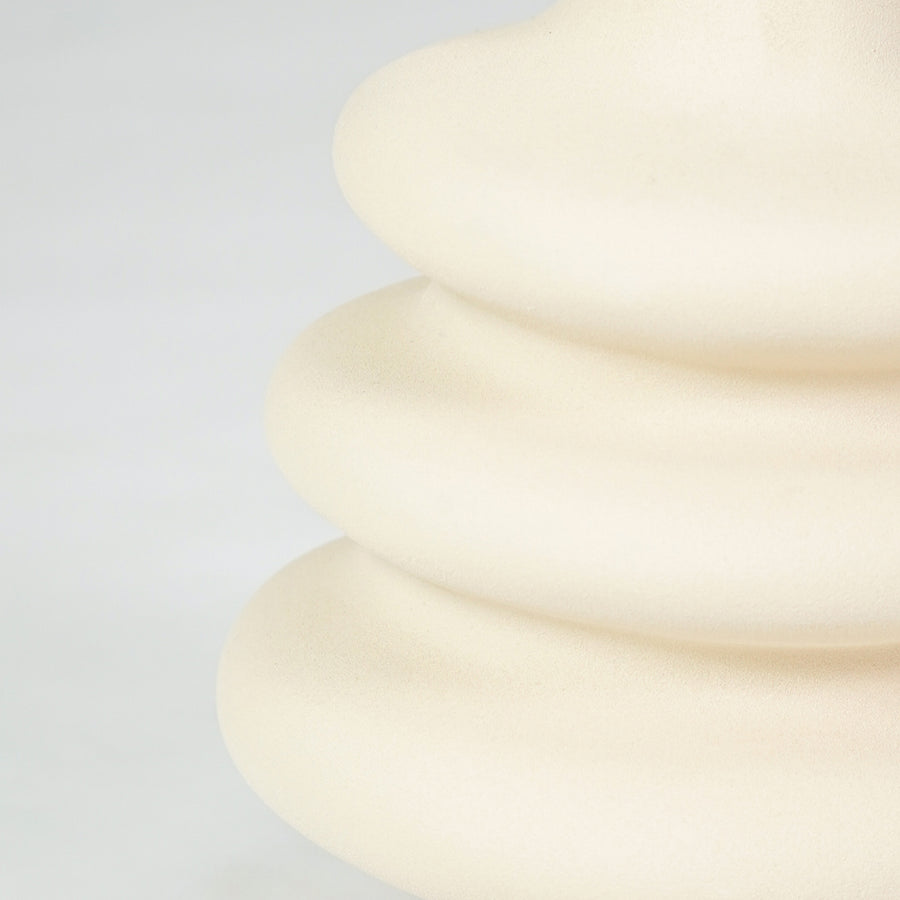 Closeup image of cream ceramic layered vase for modern shelf placement with smooth matte artistic finish styling.