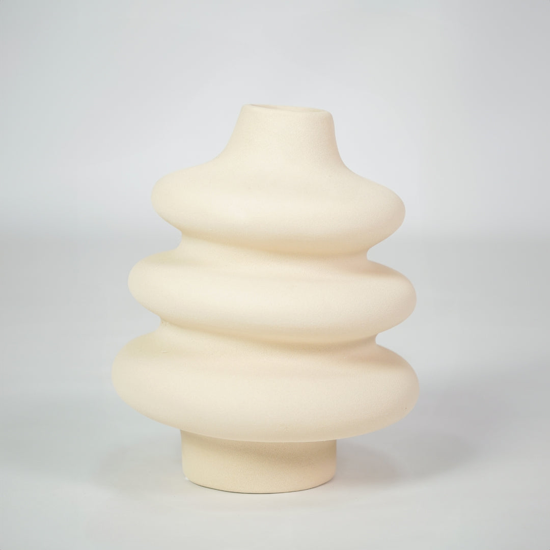 Cream textured ceramic vase for modern shelf placement and elegant indoor home decor styling accent piece.