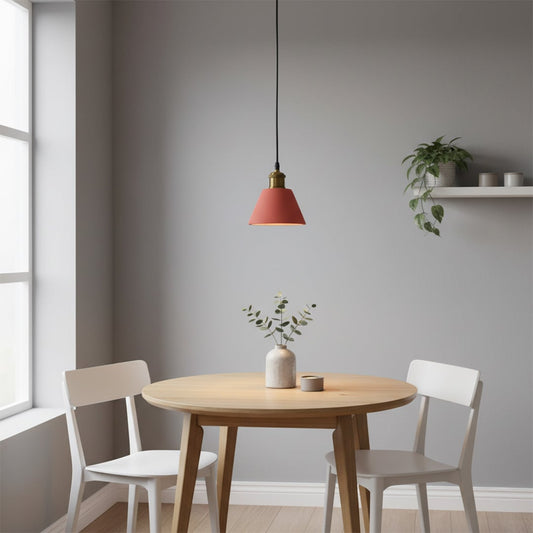 Terracotta cone pendant light glowing softly above a round wooden dining table with a small vase and two white chairs.