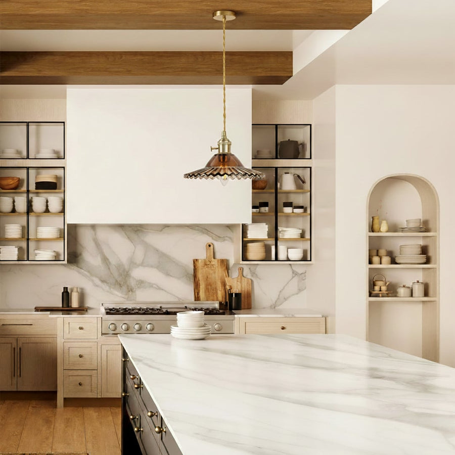Scalloped metal pendant light with brass accents enhancing modern kitchen decor with warm vintage charm.