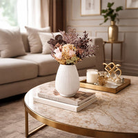 White ceramic decorative vase styled with flowers on a marble coffee table for elegant luxury home decor settings.