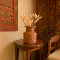 Terracotta brown ceramic vase with textured design styled on shelf adds warm earthy tone to modern home decor.
