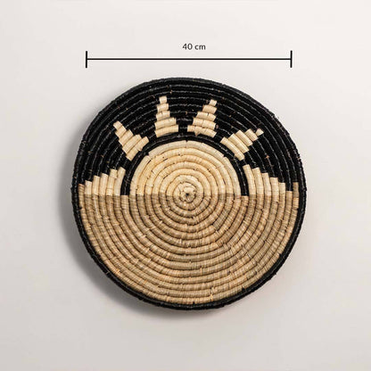 Oval handcrafted natural seagrass wall basket with green leaf pattern on white background image.