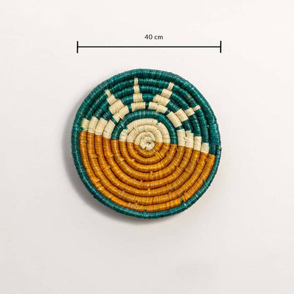 Round handcrafted black and natural seagrass wall basket with sunrise pattern on white background image.