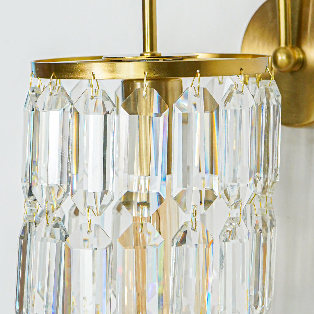 Close view of gold wall light with premium crystal prisms reflecting warm light creating luxurious ambiance in modern home interior.