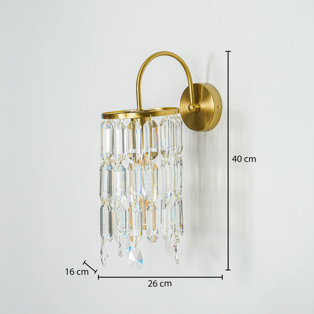 Gold wall light with crystal glass drops mounted on neutral wall background 40 cm height 26 cm width 16 cm depth perfect for luxury interior lighting.

