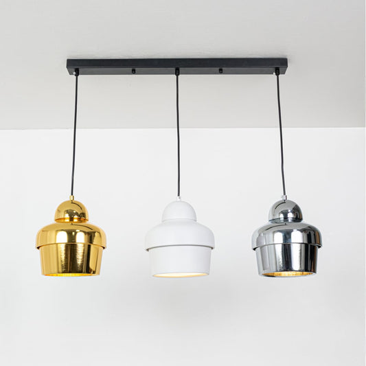 Three pendant light glowing warmly with metallic dome shades ideal for dining and living room ceiling decor.