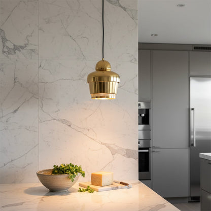 Glass pendant light with gold metal finish hanging above kitchen counter adding warm ambient lighting to modern interior.
