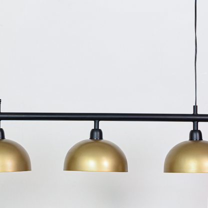 Closeup of black and gold metal triple pendant light showcasing refined finish and craftsmanship.
