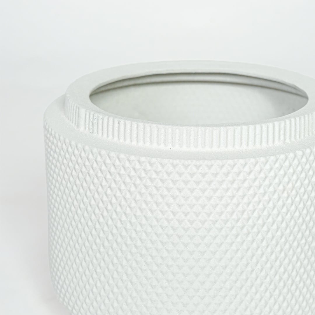 Detailed closeup of white ceramic planter showcasing textured surface and round contemporary design.