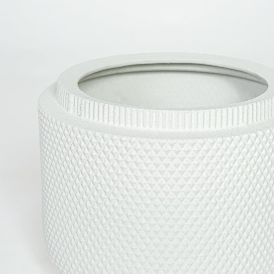 Detailed closeup of white ceramic planter showcasing textured surface and round contemporary design.