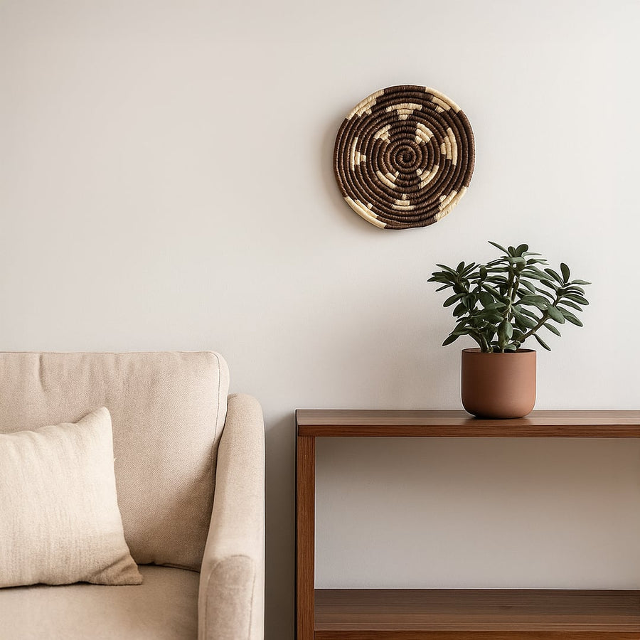 Decorative round wall basket styled above console with plant and sofa creating warm modern living room Decor atmosphere.