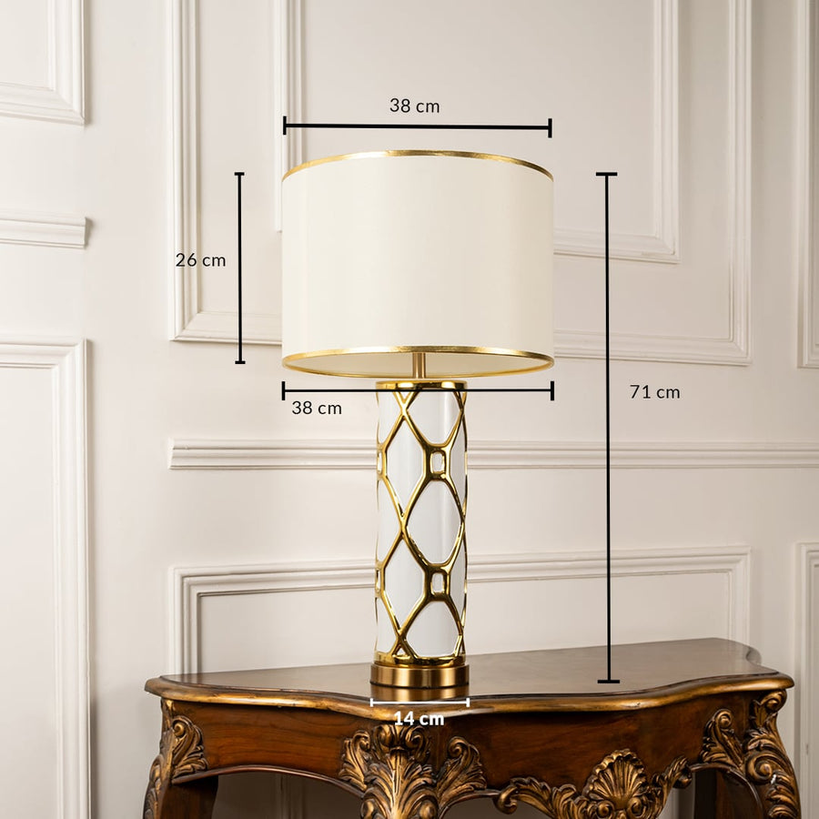 White shade gold lattice frame table lamp on carved console table with light off for luxurious decorative décor.