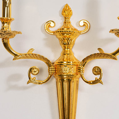 Closeup of golden wall light with two bulb holders elegant decorative fixture for luxury interior placement.