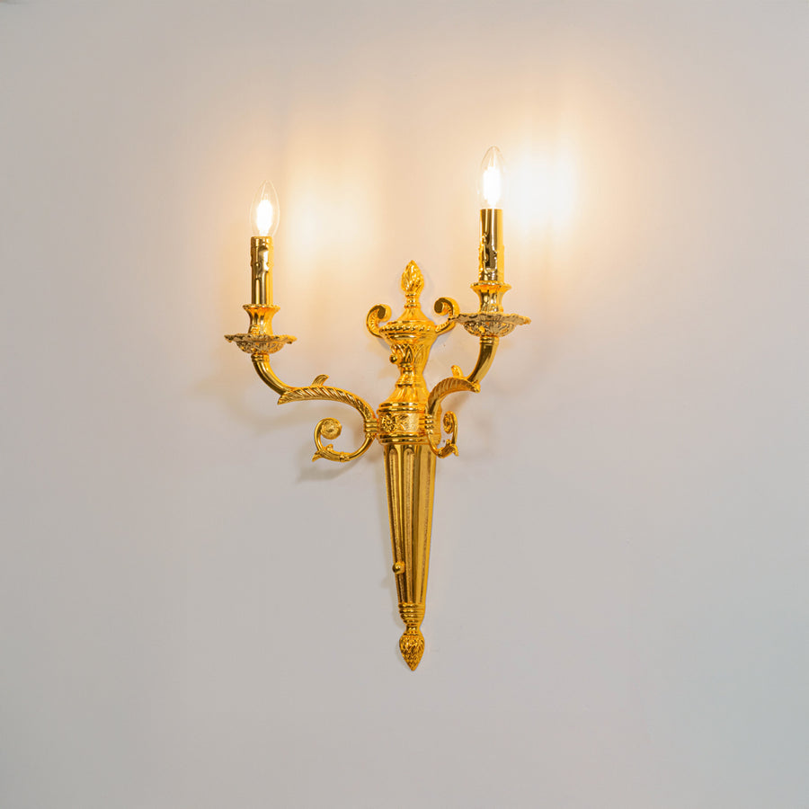 Gold metal crystal wall light on white background with candle style bulbs for elegant vintage interior decor.