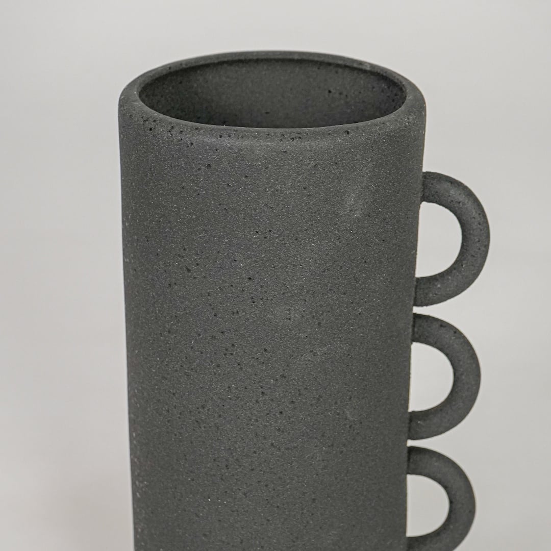 Closeup black ceramic textured decorative vase surface detail modern tall flower vase for table shelf console home decor styling.