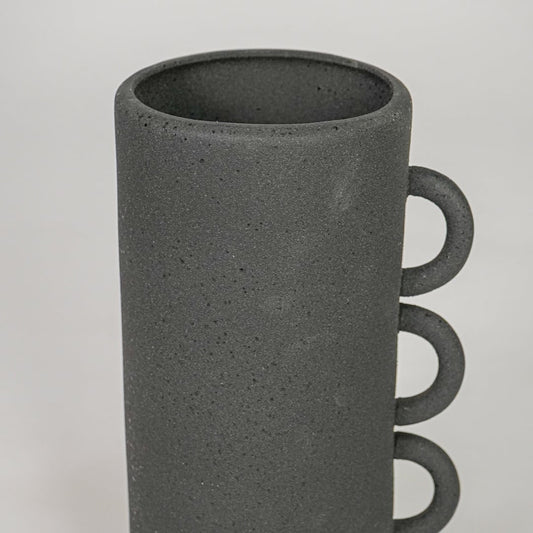 Closeup black ceramic textured decorative vase surface detail modern tall flower vase for table shelf console home decor styling.