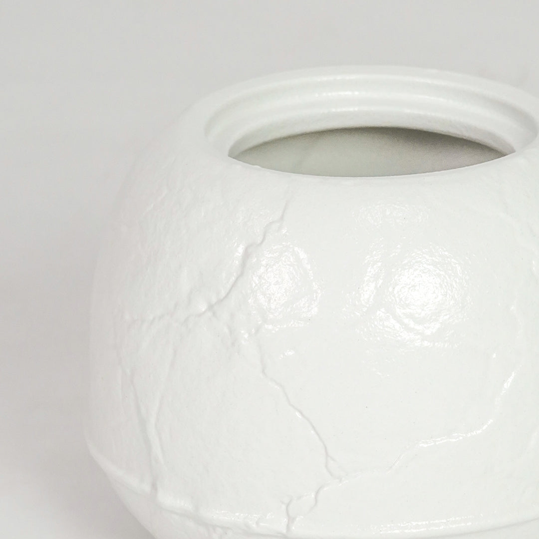 Closeup image of white ceramic round vase for elegant tabletop decor styling with subtle textured matte finish.