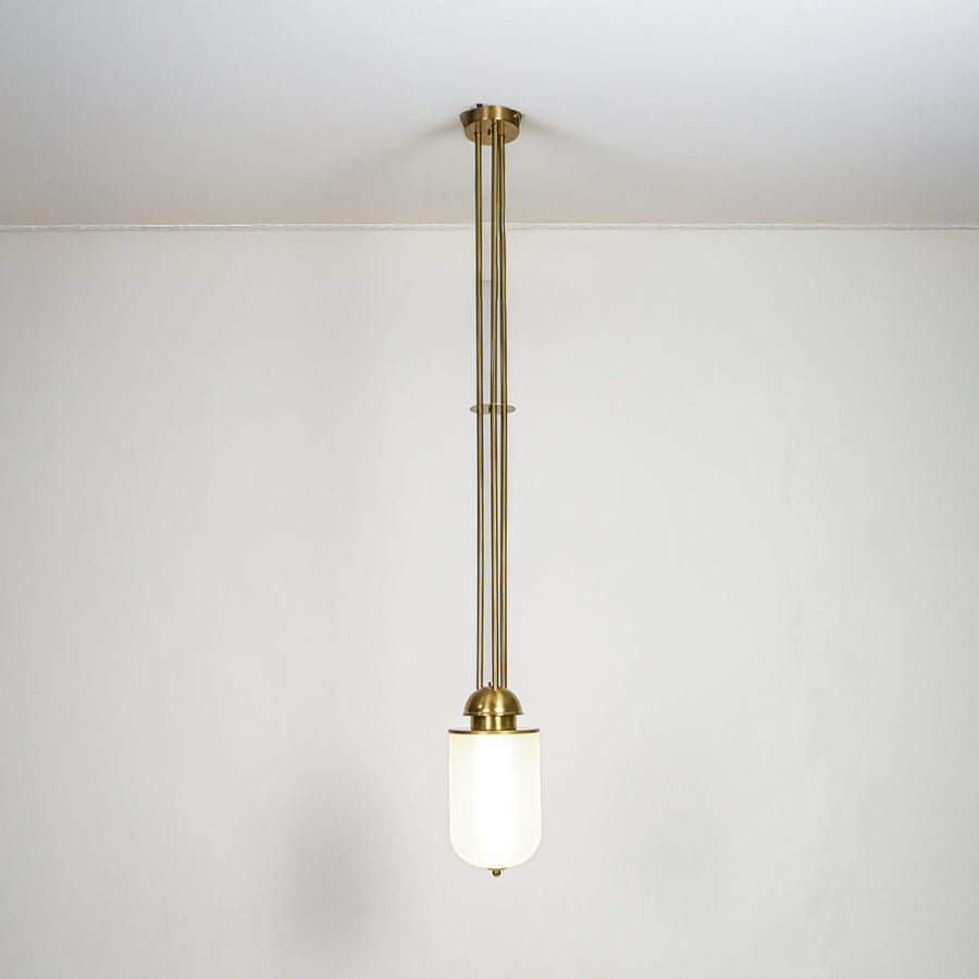Gold metal and white glass pendant light with minimalist design for modern home decor spaces.
