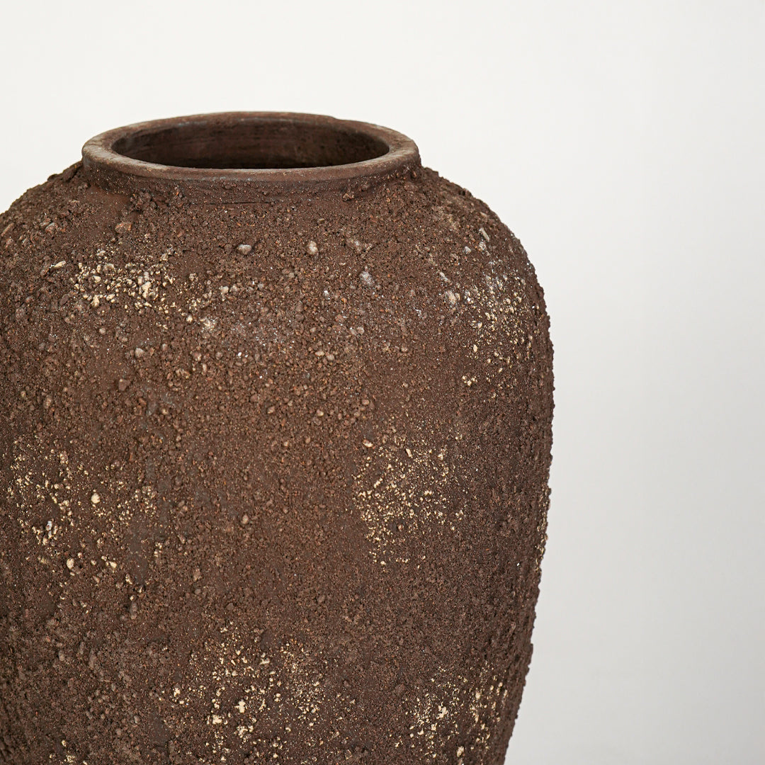 Closeup image of brown ceramic decorative vase for modern living room styling with textured rustic finish.