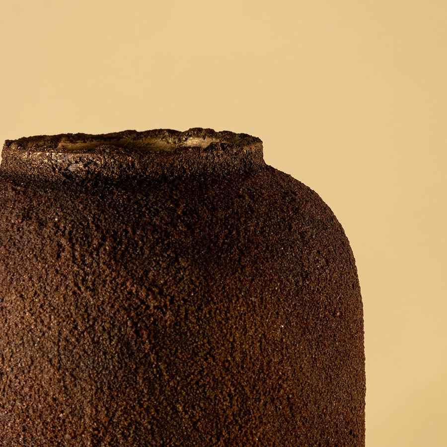 Brown ceramic floor vase with textured rustic finish styled with dried pampas grass for elegant home decor.