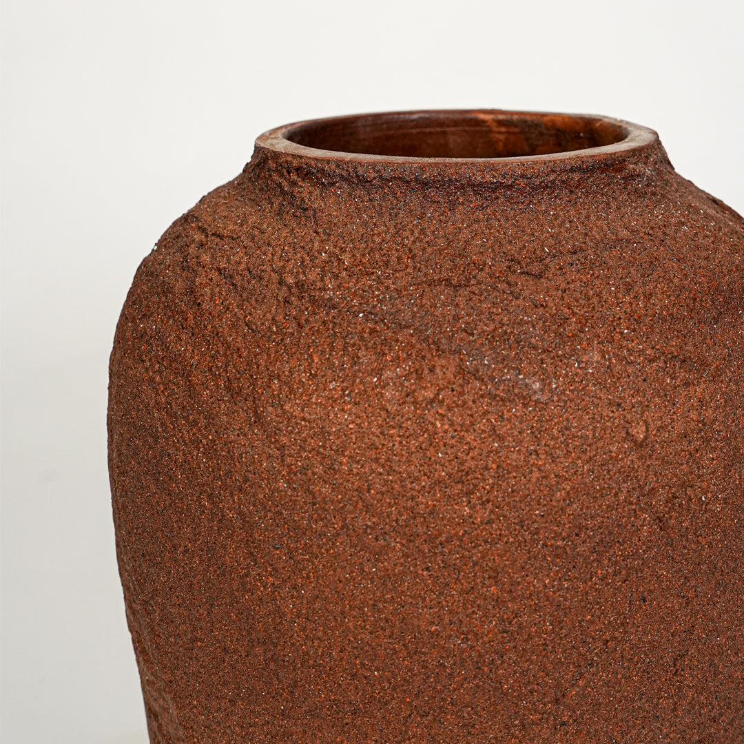 Closeup image of terracotta ceramic rustic vase for modern tabletop decor styling with earthy matte finish.
