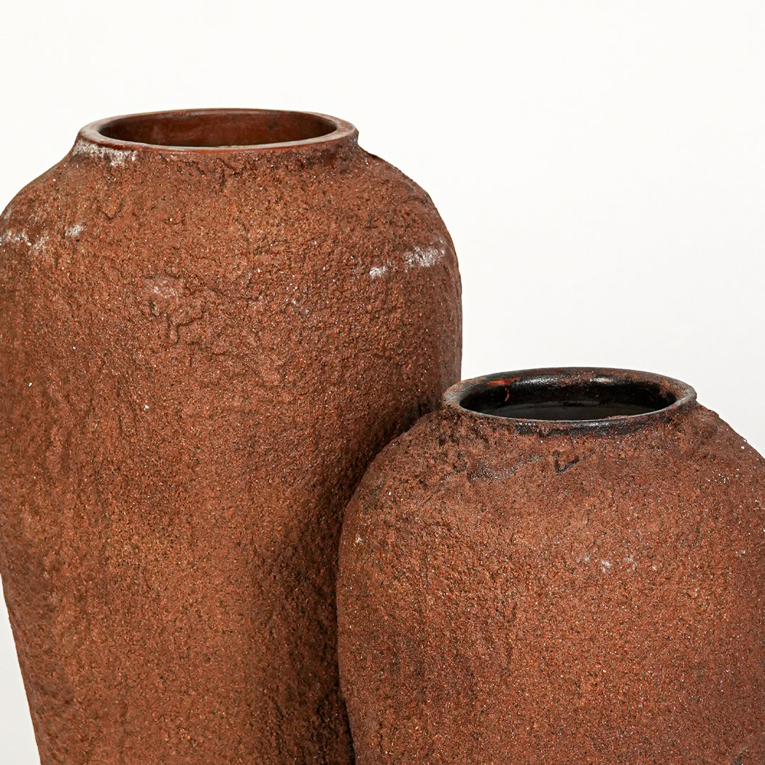 Closeup image of terracotta ceramic vase set for modern interior decor styling with rustic textured finish.