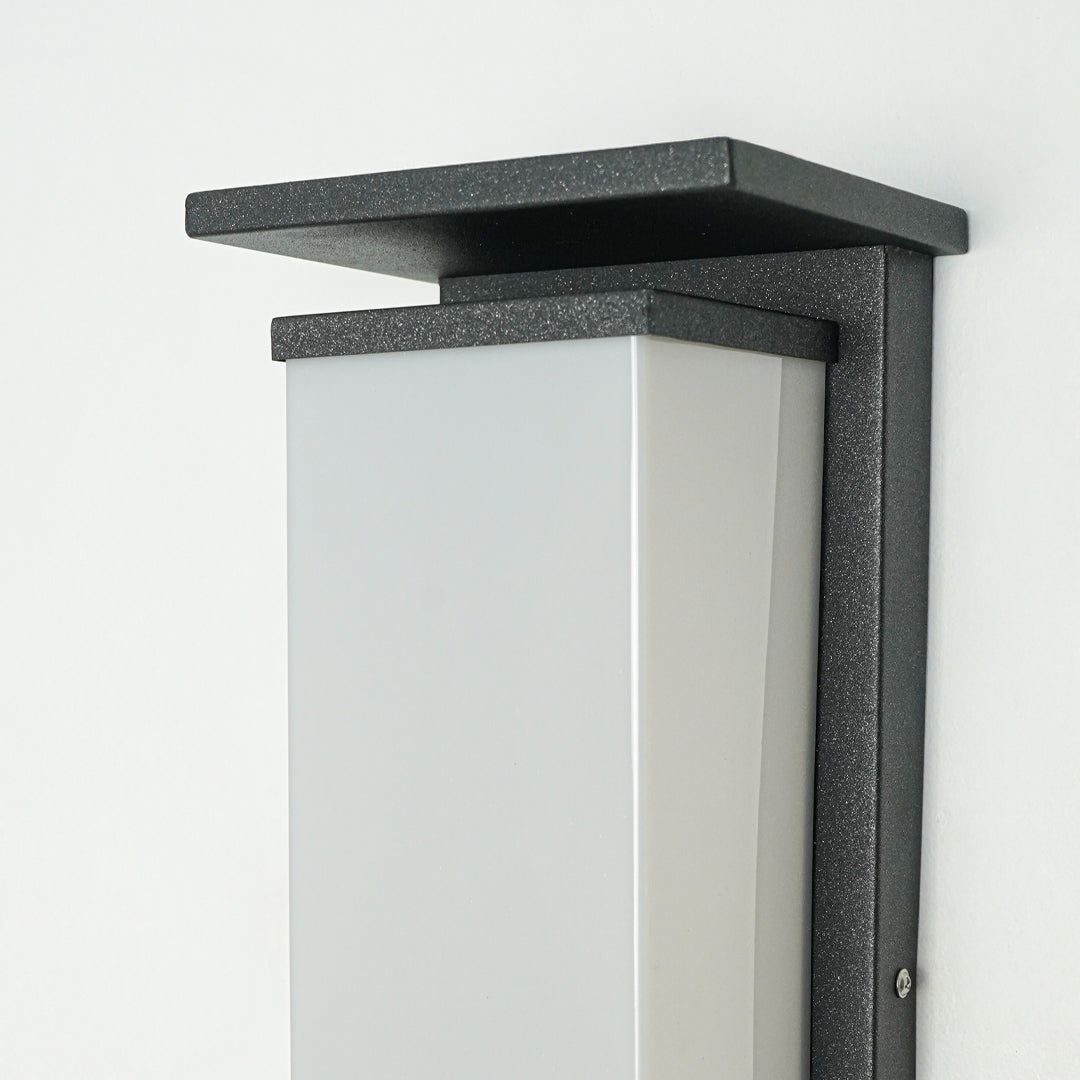 Modern outdoor wall light with black metal frame and frosted glass panel mounted on neutral wall background ideal for exterior home lighting.